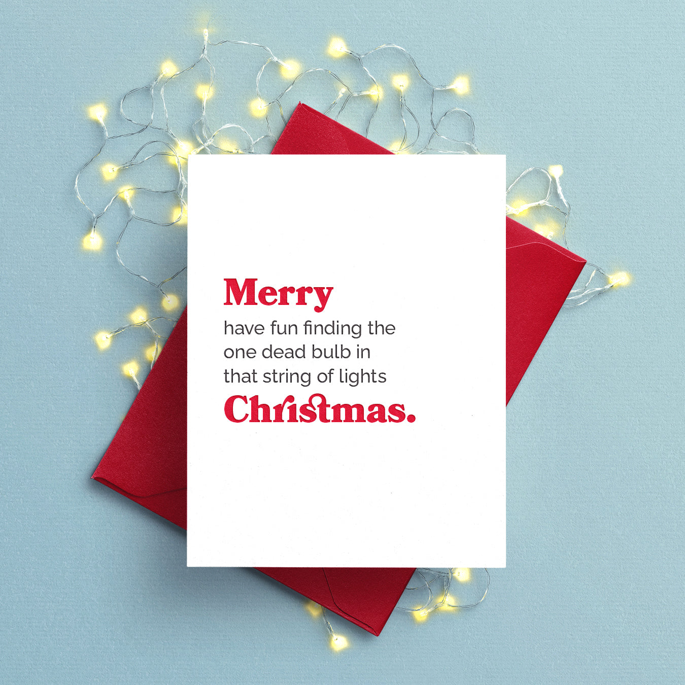 Christmas card with text: Merry have fun finding the one dead bulb in that string of lights Christmas. Letterpress printed red and black text on white paper with red envelope.