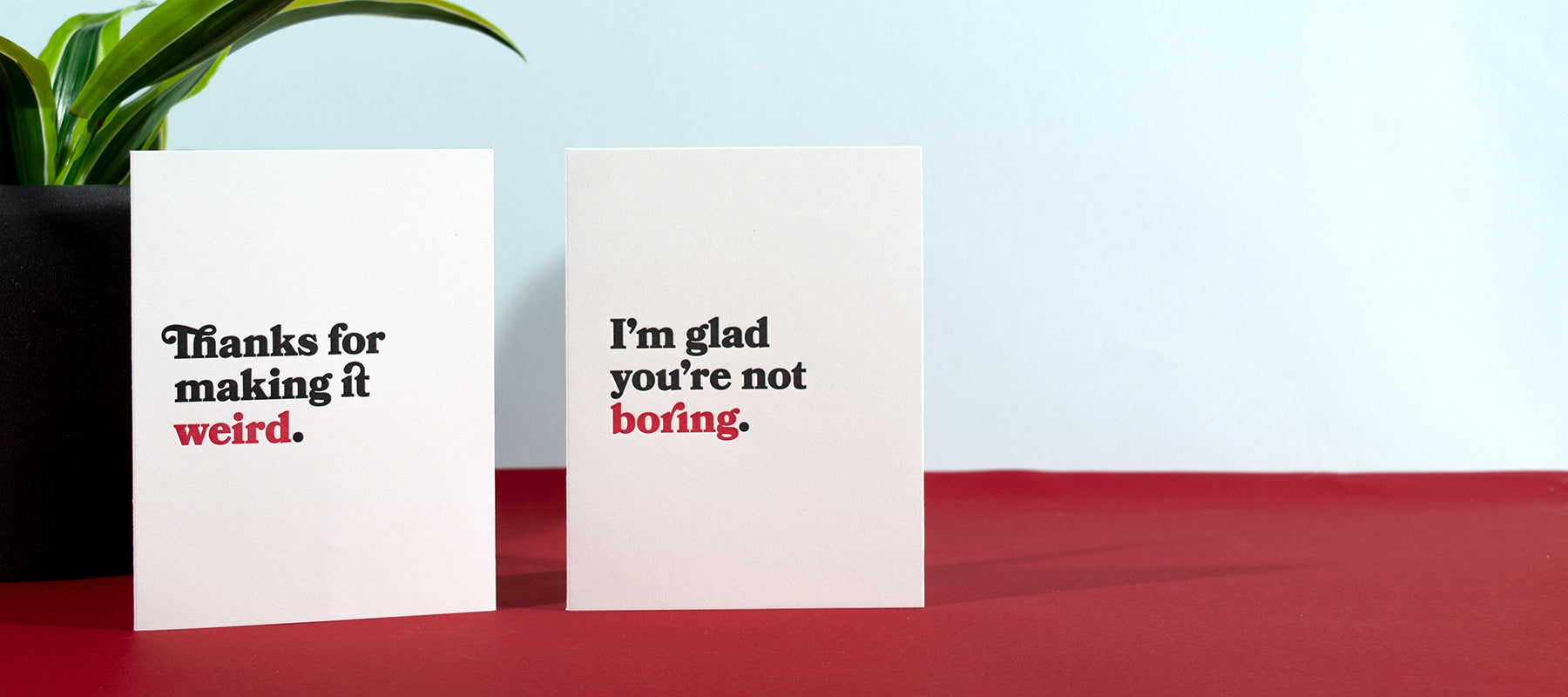 Two letterpress greeting cards, with black and red text on white paper.