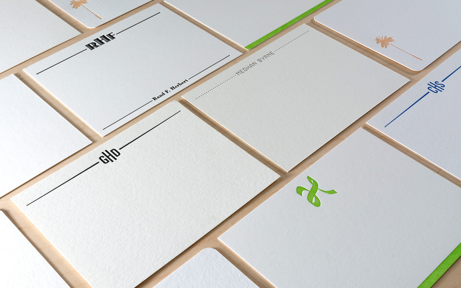 Angled grid of letterpress printed custom notecards in different colors and styles.